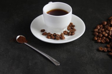 Köpüklü kahve içeceği. Siyah arka planda şeffaf bir bardakta kapuçino ya da latte..