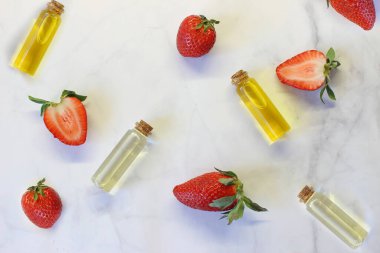Olgun çileklerin yanında aroma ve lezzet arttırıcı, açık arkaplanda.