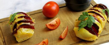 Salam, peynir, ketçap, sarımsak ve otla doldurulmuş patates. Fırınlanmış bütün patatesler dilimlenmiş ve doldurulmuş.