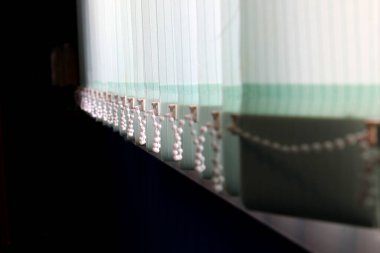 Pencerenin arka planına karşı kapalı dikey panjurlar.