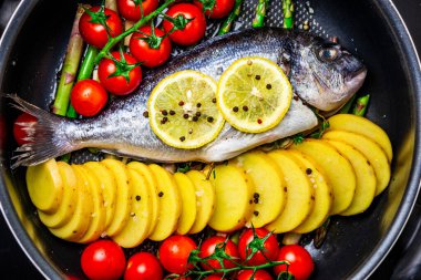 Taze sebzeli, domatesli, patatesli, limonlu ve kuşkonmazlı çiğ balık.