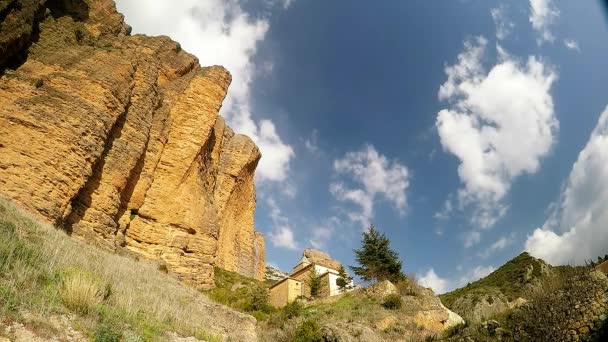 El lapso de tiempo de un gran acantilado de piedra caliza con pequeño monasterio en el pueblo en el día soleado — Vídeos de Stock