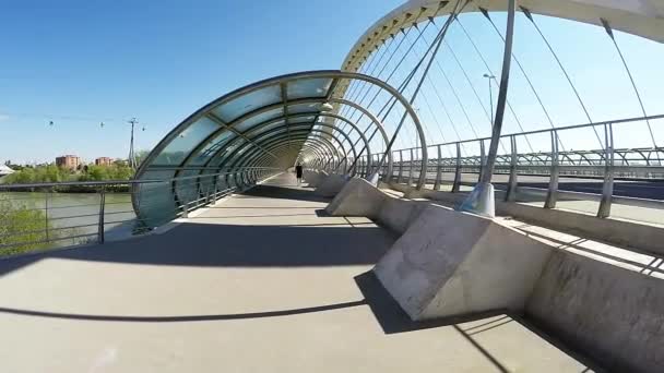 Spaziergänger spazieren an einem sonnigen Tag über die futuristische Brücke — Stockvideo