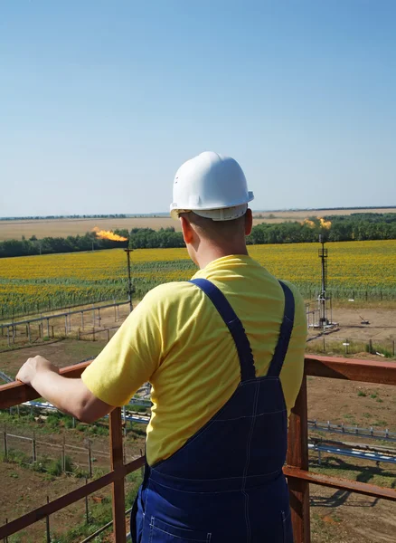 Olie-industrie. Werken op de toren kijken olie vlam fakkel met — Stockfoto