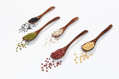 Tahta kaşık tahıl, mercimek, bezelye ve fasulye beyaz arka planda izole