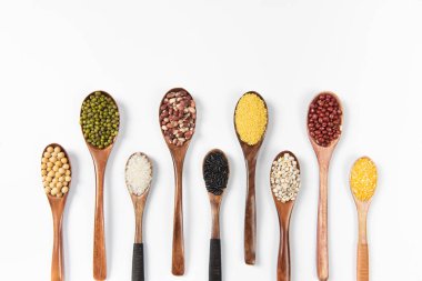 Tahta kaşık tahıl, mercimek, bezelye ve fasulye beyaz arka planda izole