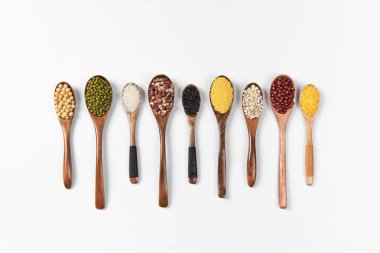 Tahta kaşık tahıl, mercimek, bezelye ve fasulye beyaz arka planda izole