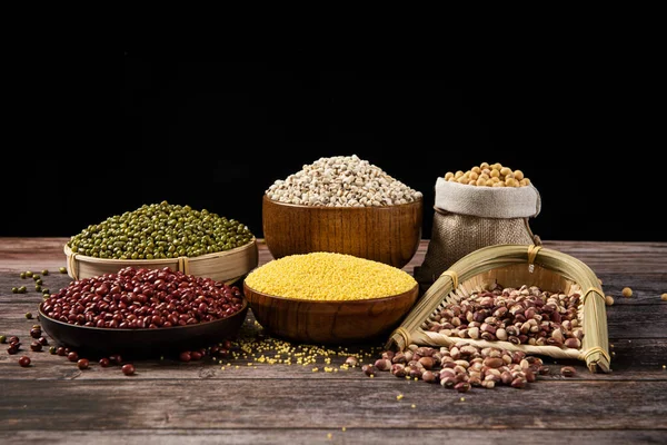 Collection of different cereals, grains and beans on wooden background