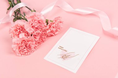 Pembe karanfil çiçeği ve pembe arka plan. Anneler Günün kutlu olsun.