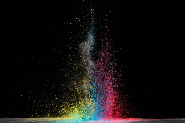 Explosion of colored powder isolated on black background. Abstract colored background