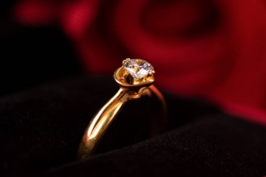 Çiçek arkaplanlı kırmızı mücevher kutusunda elmas yüzük