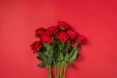 Kırmızı arka planda bir buket gül. 
