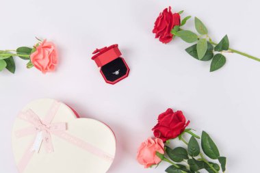 Elmas yüzük, gül ve beyaz arka planda hediye kutusu, Sevgililer Günü