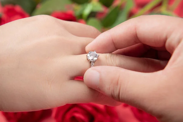 groom wears ring on bride\'s finger in wedding ceremony