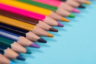 Mavi arkaplanda renkli kalemler dizisi