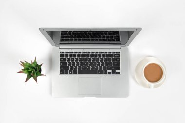 Laptop bilgisayarı, kahve ve ofis malzemeleri olan beyaz ofis masası. Kopyalama alanı olan üst görünüm, düz yatay.
