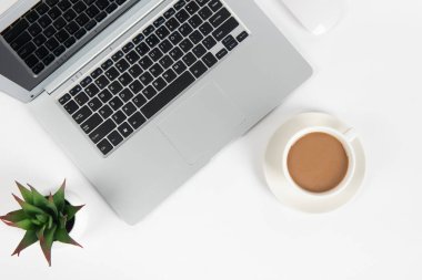 Laptop bilgisayarı, kahve ve ofis malzemeleri olan beyaz ofis masası. Kopyalama alanı olan üst görünüm, düz yatay.