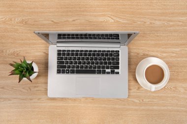 Laptop bilgisayarı, kahve ve ofis malzemeleri olan ofis masası. Kopyalama alanı olan üst görünüm, düz yatay.