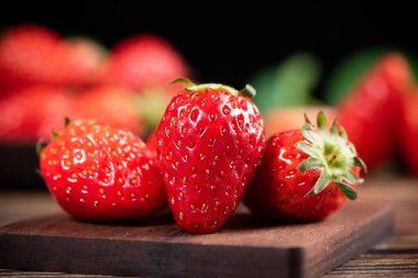 Tahta masadaki taze çilekleri kapatın.