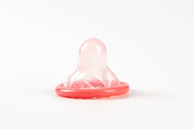 Pembe prezervatif beyaz arka planda izole edilmiş. Güvenli seks yapıyorlar.