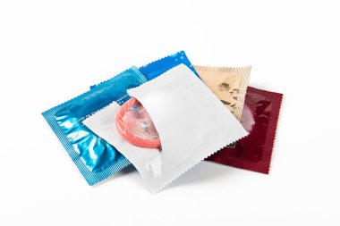 Pembe açık prezervatif ve prezervatif paketinde beyaz arka planda izole edilmiş.. 