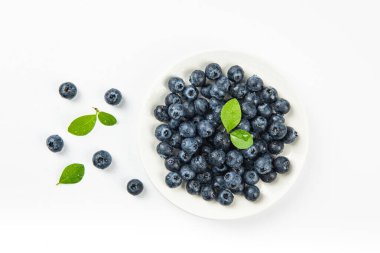 Beyaz zemin üzerinde su damlaları olan taze yaban mersini.