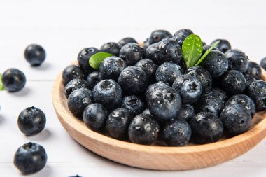 Ahşap zemin üzerinde su damlaları olan taze yaban mersini.