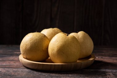 Tahta bir masada taze sarı armut yakın plan.