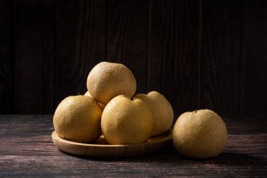 Tahta bir masada taze sarı armut yakın plan.