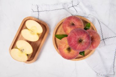 Kırmızı elmalar beyaz masada izole edilmiş.