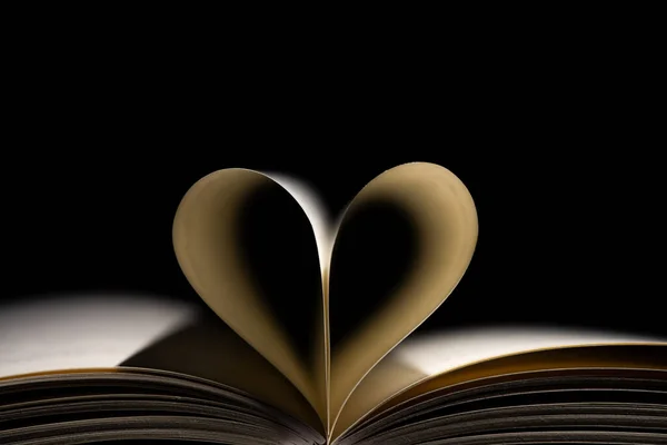 open books with a heart on black background