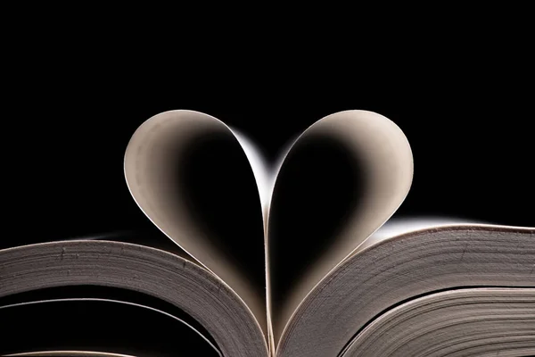 open books with a heart on black background