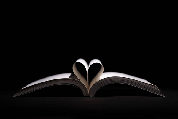 Open books with a heart on black background