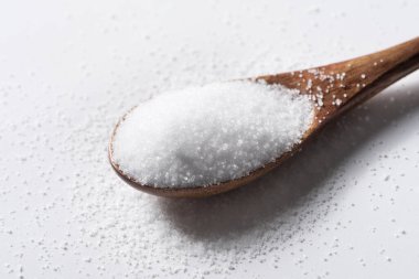 Ahşap kaşık arka planında bir yığın tuz.