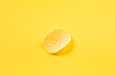 Sarı arkaplanda kırpma yolu ile izole edilmiş bir patates cipsi.