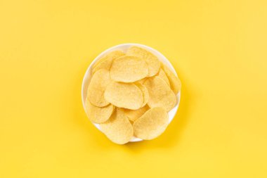 Kırpma yolu ile sarı arkaplanda izole edilmiş patates cipsi grubu