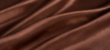 Kahverengi ya da çikolata rengi ipek kumaş arka plan. Kumaş yumuşak dalga. Saten hazineleri.