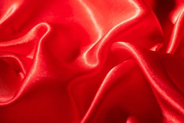 Soyut kırmızı ipek kumaş dokusu arkaplanı. Kumaş yumuşak dalga. Saten hazineleri.