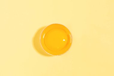 Sarı arka planda kırık bir yumurta..