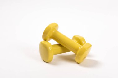 Beyaz arkaplanda izole edilmiş iki sarı dambıl.