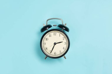 mavi arkaplanda siyah alarm saati izole edildi