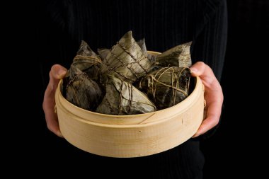 El ele zongzi ya da pirinç köftesi. Ejderha Teknesi Festivali geleneği.