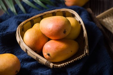 Ripe fresh mango fruit isolated on wood background