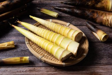 Tahta arka planda taze toplanmış bambu filizleri