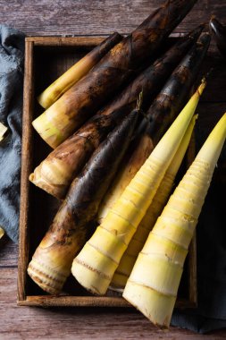 Tahta arka planda taze toplanmış bambu filizleri