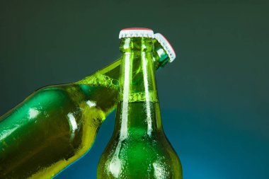 Yeşil bira şişesi mavi arka planda şerefe