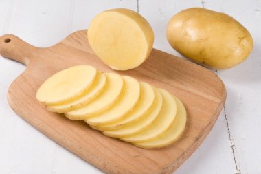 Beyaz ahşap arka planda çiğ patates