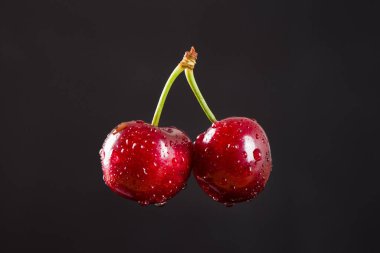 Siyah arka planda izole edilmiş kirazlar.