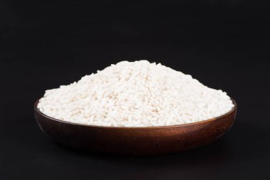 Siyah zemin üzerinde çiğ organik beyaz pirinç, yapışkan pirinç ya da yapışkan pirinç.