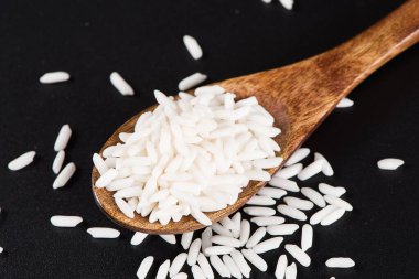 Siyah zemin üzerinde çiğ organik beyaz pirinç, yapışkan pirinç ya da yapışkan pirinç.